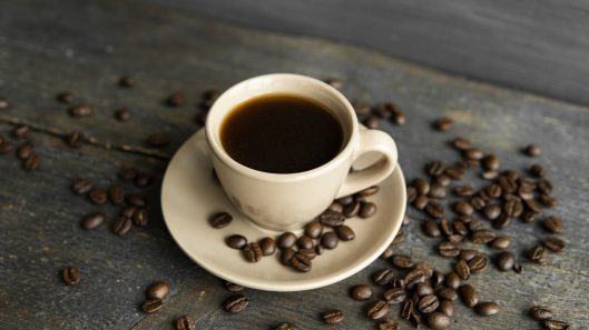 34097652_coffee-cup-with-roasted-coffee-beans-on-wooden-table-background-mug-of-black-coffe-with-scattered-coffee-beans-on-a-wooden-table-fresh-coffee-beans